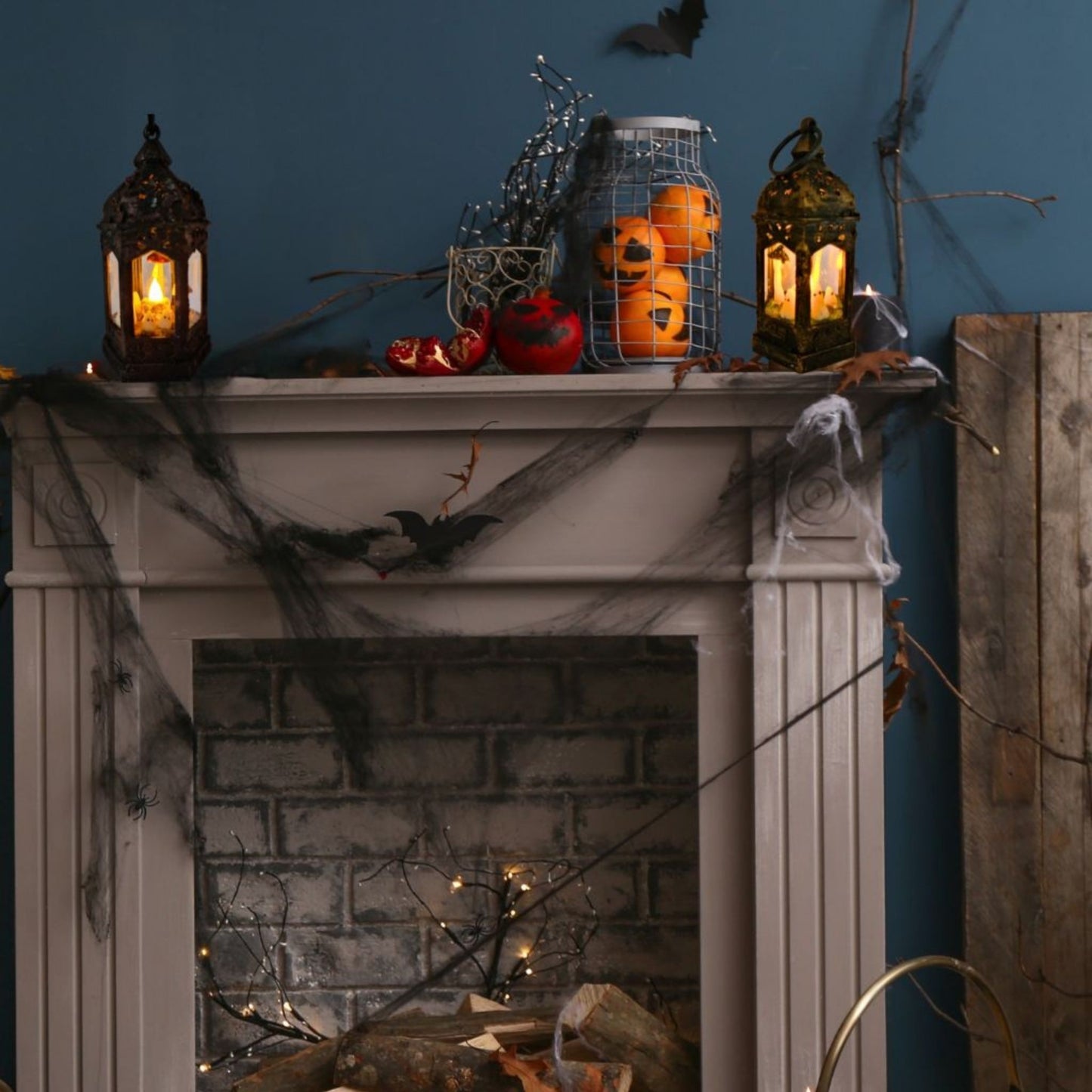 Pair of handmade ghost lanterns glowing on fireplace – cosy gothic Halloween home décor.